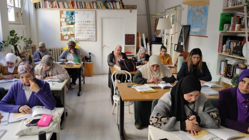 lezione scuola donne, classe piena di studentesse che prendono appunti